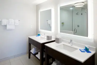 a bathroom with two sinks and a large mirror at Holiday Inn Express & Suites - Cincinnati North - Liberty Way by IHG in West Chester