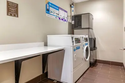 a laundry room with a washing machine and a counter at Comfort Suites Florence - Cincinnati South in Florence