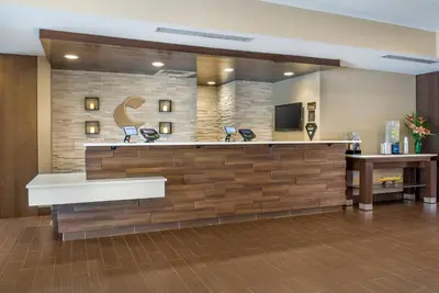 a lobby of a hotel with a counter and a tv at Comfort Suites Florence - Cincinnati South in Florence