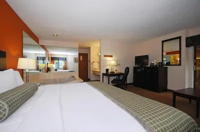 a hotel room with a bed and a bath tub at Baymont by Wyndham Delaware in Delaware