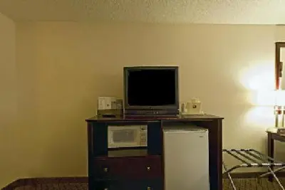 a living room with a tv and a microwave and a refrigerator at Baymont by Wyndham Delaware in Delaware
