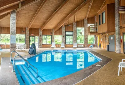 a large indoor pool in a building with wooden ceilings at Baymont by Wyndham Delaware in Delaware