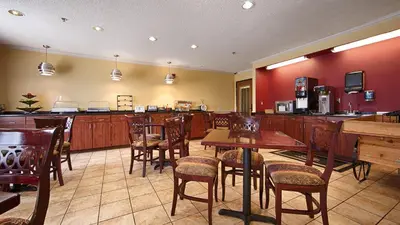 a restaurant with tables and chairs and a bar at Baymont by Wyndham Delaware in Delaware