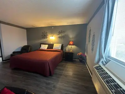 a bedroom with a bed and a chair in it at Fairway Inn Florence Indiana in Florence