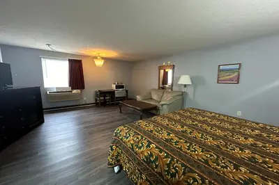 a hotel room with a bed and a chair at Fairway Inn Florence Indiana in Florence