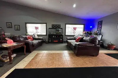 a living room with leather couches and a tv at Fairway Inn Florence Indiana in Florence