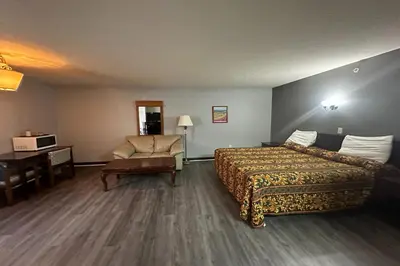 a hotel room with a bed and a chair at Fairway Inn Florence Indiana in Florence