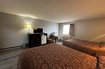 a hotel room with two beds and a television at Fairway Inn Florence Indiana in Florence