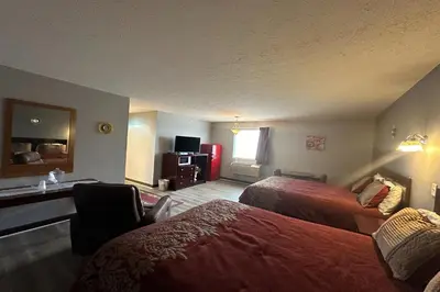 a hotel room with two beds and a desk at Fairway Inn Florence Indiana in Florence