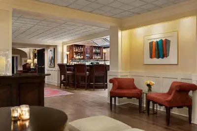 a lobby with red chairs and a bar at The Glidden House in Cleveland