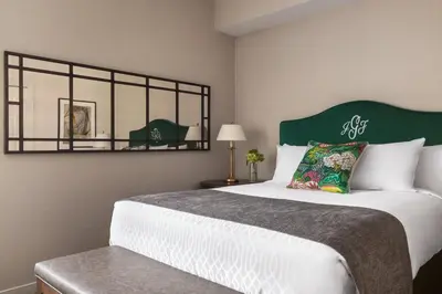 a bedroom with a large bed with a green headboard at The Glidden House in Cleveland
