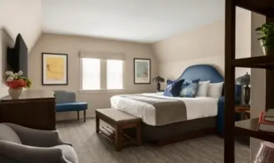 a bedroom with a bed and a desk and a chair at The Glidden House in Cleveland