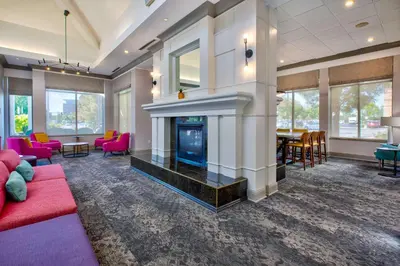 a living room with a fireplace and a red couch at Hilton Garden Inn Dayton/ Beavercreek in Beavercreek