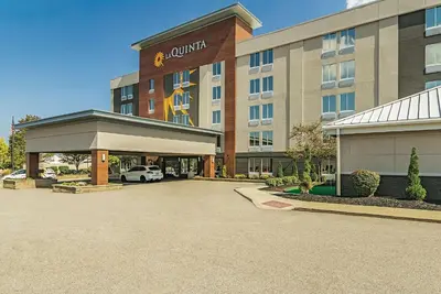 a hotel with a car parked in a parking lot at La Quinta by Wyndham Cleveland Airport West in North Olmsted