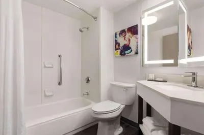 a white bathroom with a toilet and a sink at La Quinta by Wyndham Cleveland Airport West in North Olmsted