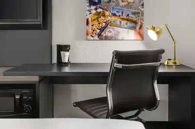 a black desk with a chair and a lamp at La Quinta by Wyndham Cleveland Airport West in North Olmsted