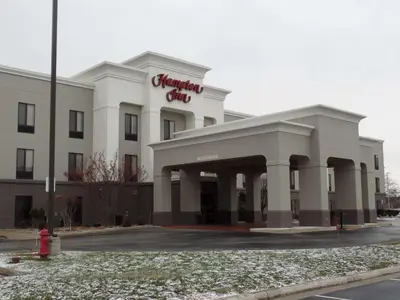 a white building with a red sign on it at Hampton Inn Bowling Green in Bowling Green