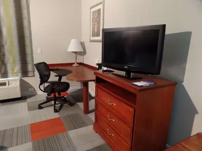 a room with a television on a dresser with a desk at Hampton Inn Bowling Green in Bowling Green