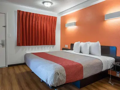 a large bed in a room with a red curtain at Motel 6-Columbus, OH - OSU in Columbus