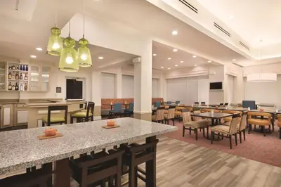 a restaurant with tables and chairs and a cafeteria at Hilton Garden Inn Akron-Canton Airport in North Canton