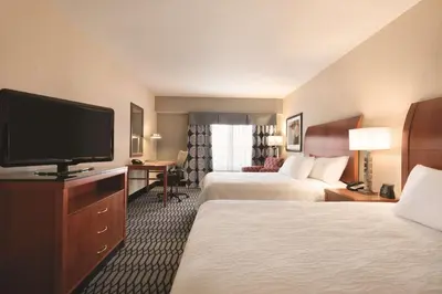 a hotel room with two beds and a flat screen tv at Hilton Garden Inn Akron-Canton Airport in North Canton