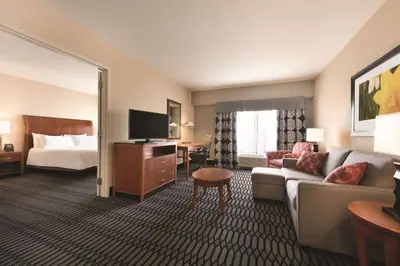 a hotel room with a couch and a bed at Hilton Garden Inn Akron-Canton Airport in North Canton
