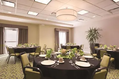 a conference room with tables and chairs and a room with at Hilton Garden Inn Akron-Canton Airport in North Canton