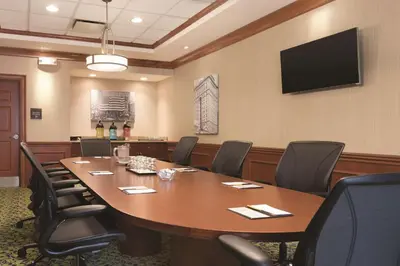 a conference room with a large wooden table and chairs at Hilton Garden Inn Akron-Canton Airport in North Canton