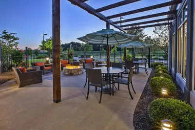 a patio with a table and chairs and an umbrella at Hilton Garden Inn Akron-Canton Airport in North Canton