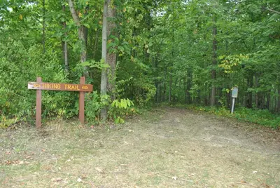 a sign for a hiking trail in the woods at Wilmington Camping Resort in Wilmington