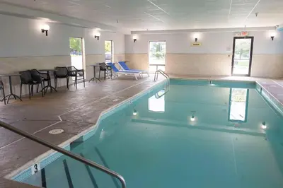 a large swimming pool with blue water in a room at Hampton Inn Kent/Akron Area in Kent