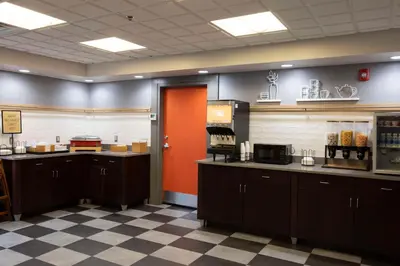 a restaurant with a red door and aasteryasteryasteryasteryasteryasteryasteryastery at Hampton Inn Kent/Akron Area in Kent