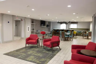 a waiting room with red chairs and a table at Hampton Inn Kent/Akron Area in Kent