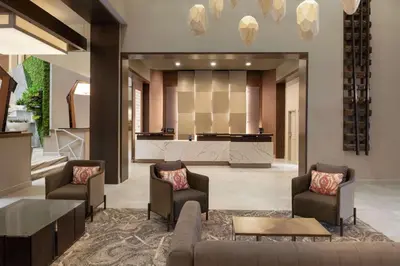 a lobby with chairs and a bar in the background at Embassy Suites by Hilton Cleveland Rockside in Independence