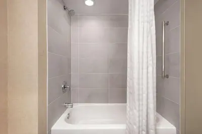 a bathroom with a bath tub with a shower curtain at Embassy Suites by Hilton Cleveland Rockside in Independence