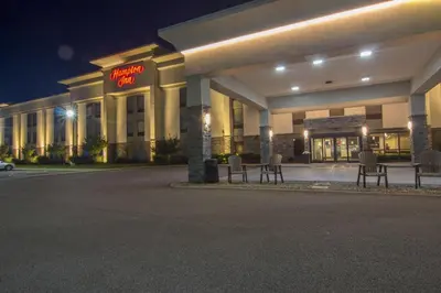 a building with chairs in front of it at night at Hampton Inn Medina in Medina