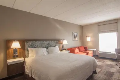 a hotel room with a bed and a chair at Hampton Inn Medina in Medina