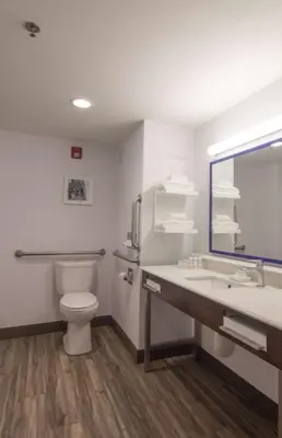 a bathroom with a toilet and a sink and a mirror at Hampton Inn Medina in Medina