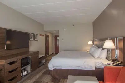 a hotel room with a bed and a flat screen tv at Hampton Inn Medina in Medina