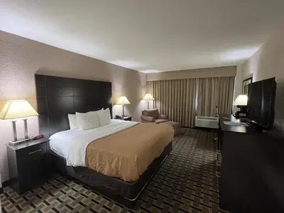 a hotel room with a large bed and a television at Quality Inn & Suites Cincinnati Downtown Area in Cincinnati