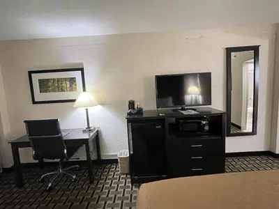 a hotel room with a bed and a desk and a television at Quality Inn & Suites Cincinnati Downtown Area in Cincinnati
