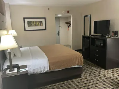 a hotel room with a bed and a flat screen tv at Quality Inn & Suites Cincinnati Downtown Area in Cincinnati