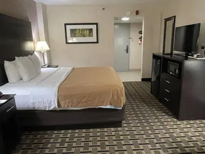 a hotel room with a bed and a flat screen tv at Quality Inn & Suites Cincinnati Downtown Area in Cincinnati
