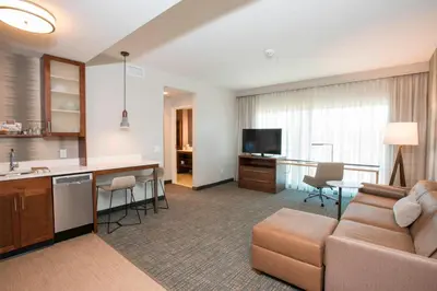 a living room with a couch and a kitchen and a television at Residence Inn by Marriott Cincinnati Midtown/Rookwood in Cincinnati
