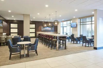 a restaurant with tables and chairs and a bar at Residence Inn by Marriott Cincinnati Midtown/Rookwood in Cincinnati