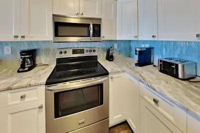 a kitchen with a stove and a microwave at Put-In-Bay Waterfront Condo #108 in Put-in-Bay