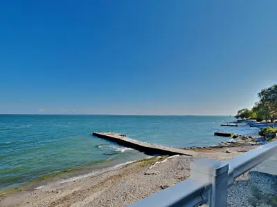 a view of a beach with a pier in the water at Put-In-Bay Waterfront Condo #108 in Put-in-Bay