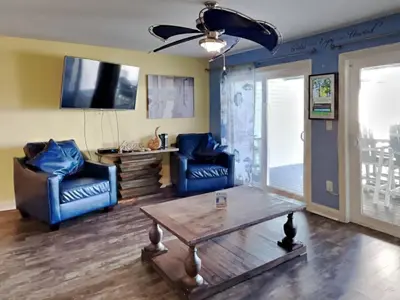 a living room with two blue chairs and a table at Put-In-Bay Waterfront Condo #108 in Put-in-Bay