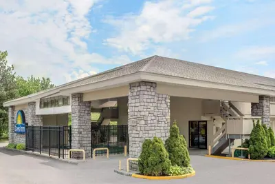 a building with a porch with a fence in front at Days Inn by Wyndham Columbus Fairgrounds in Columbus