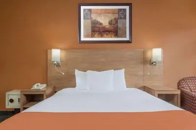 a hotel room with a bed and a phone at Days Inn by Wyndham Columbus Fairgrounds in Columbus